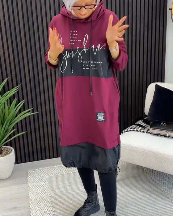 Swobodna sukienka z kapturem i kolorowym nadrukiem w bloki liter