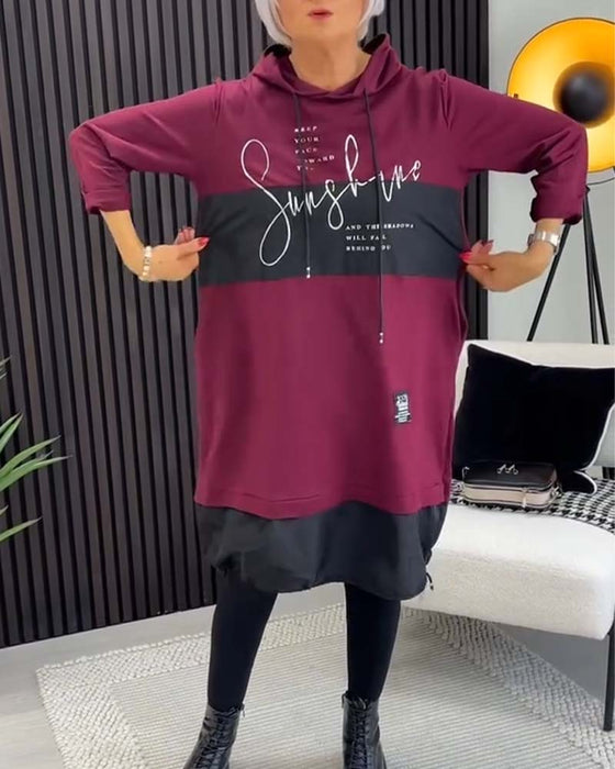 Swobodna sukienka z kapturem i kolorowym nadrukiem w bloki liter