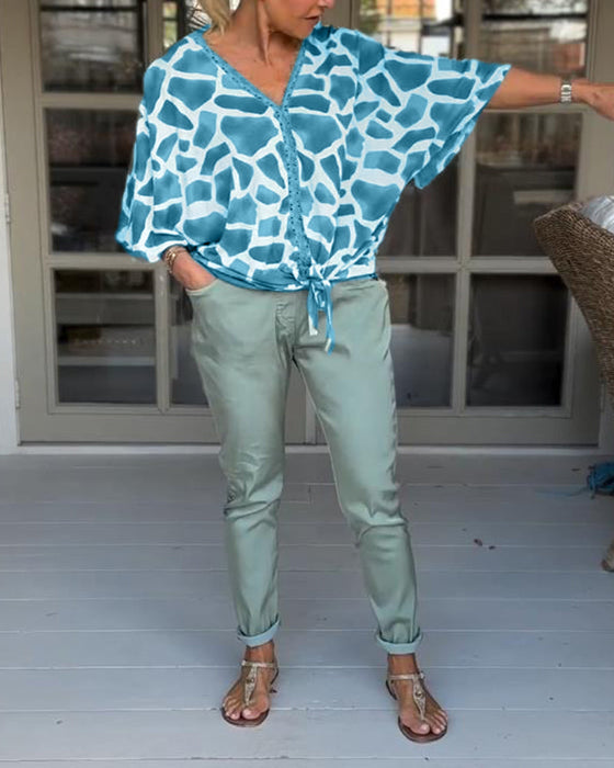 Elegancka bluzka z nadrukiem i dekoltem w kształcie litery V z rękawami nietoperzowymi